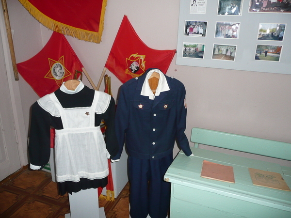 Экспозиция Школьные годы. Манекены учеников у школьной парты. На заднем плане атрибутика пионерской организации школы, 1970-1980 гг.